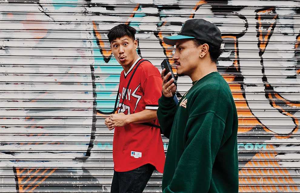 two men standing in front of a wall