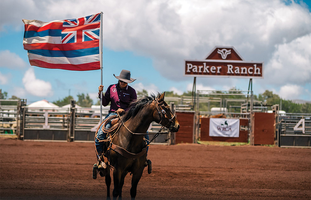 professional cowboy riding horse with flag at Parker Ranch.